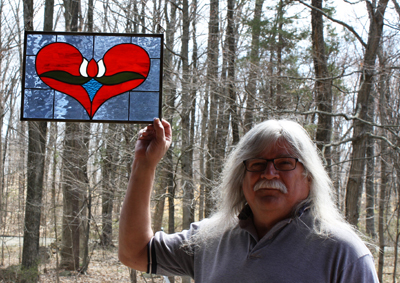 Stained glass Carl Altman with his work. Photograph by Jennifer Hetrick.